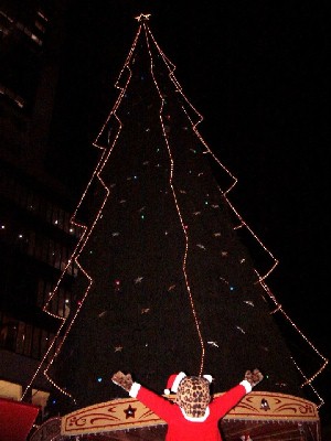 新梅田シティのクリスマスツリーの前に立つヒョウ着ぐるみのサンタ